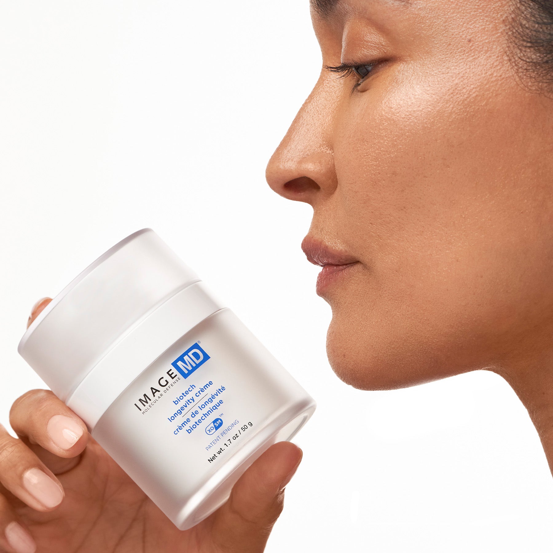 Person holding a white jar labeled 'IMAGE MD' against a neutral background