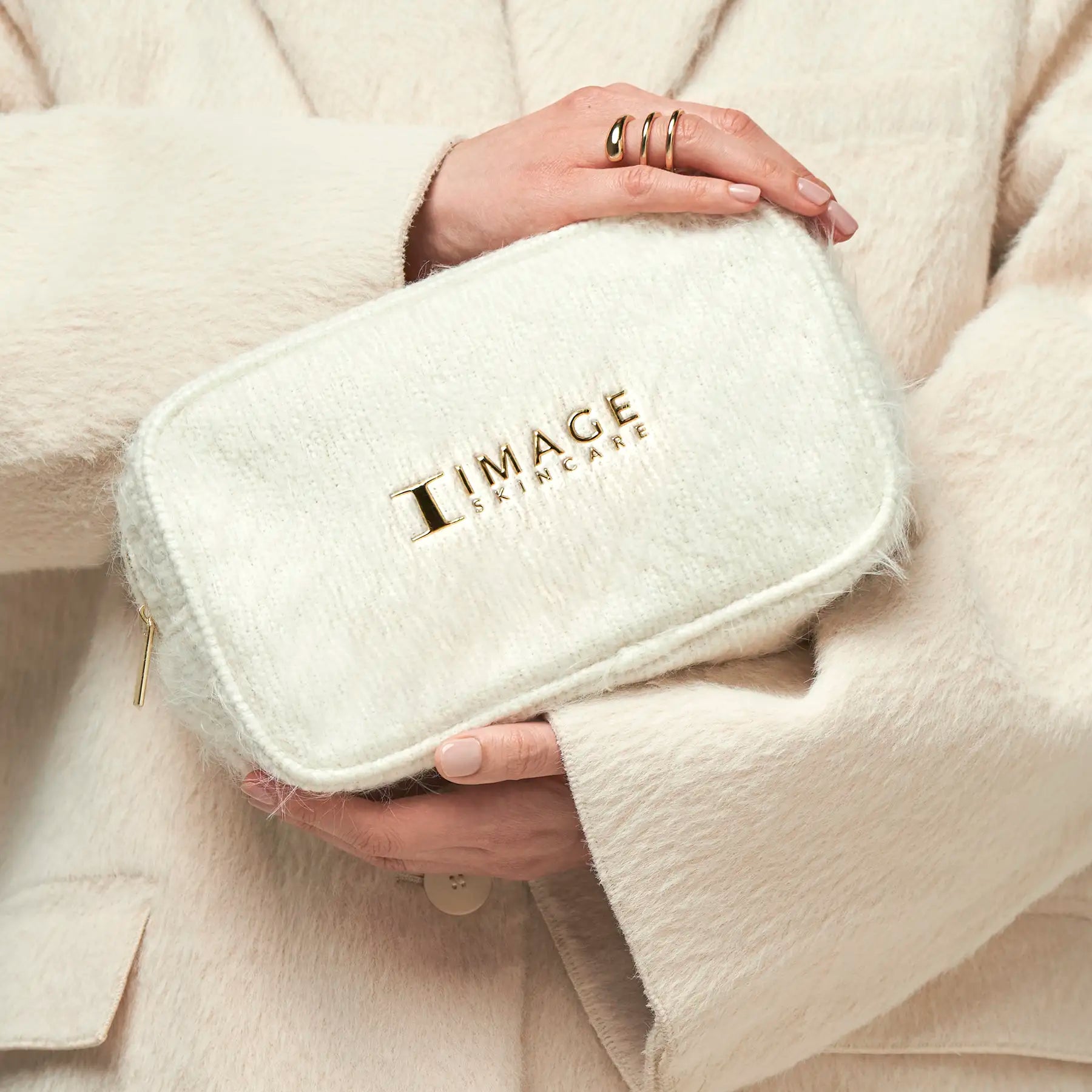 close up of model hands holding cosmetic bag