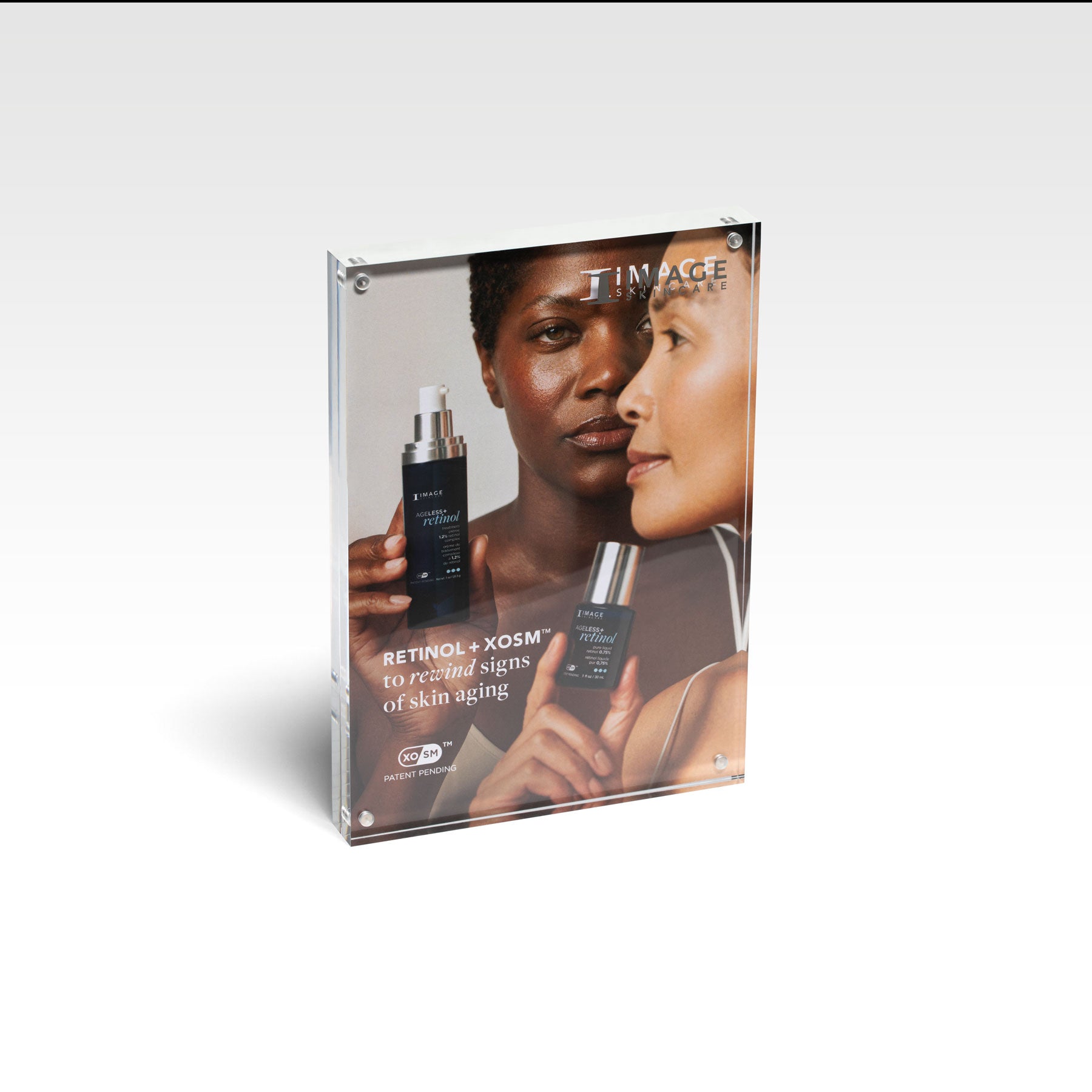 A promotional display case with the AGELESS+ retinol brand, featuring two individuals and skincare products.