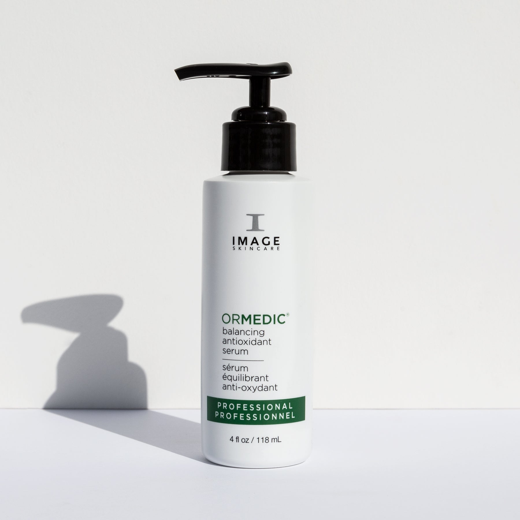 A pump bottle of IMAGE ORMedic balancing antioxidant serum on a white background with a shadow cast across the image.