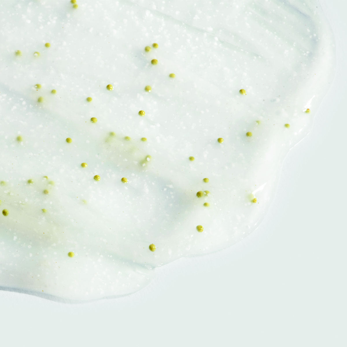 White creamy substance with small yellow particles on a white background