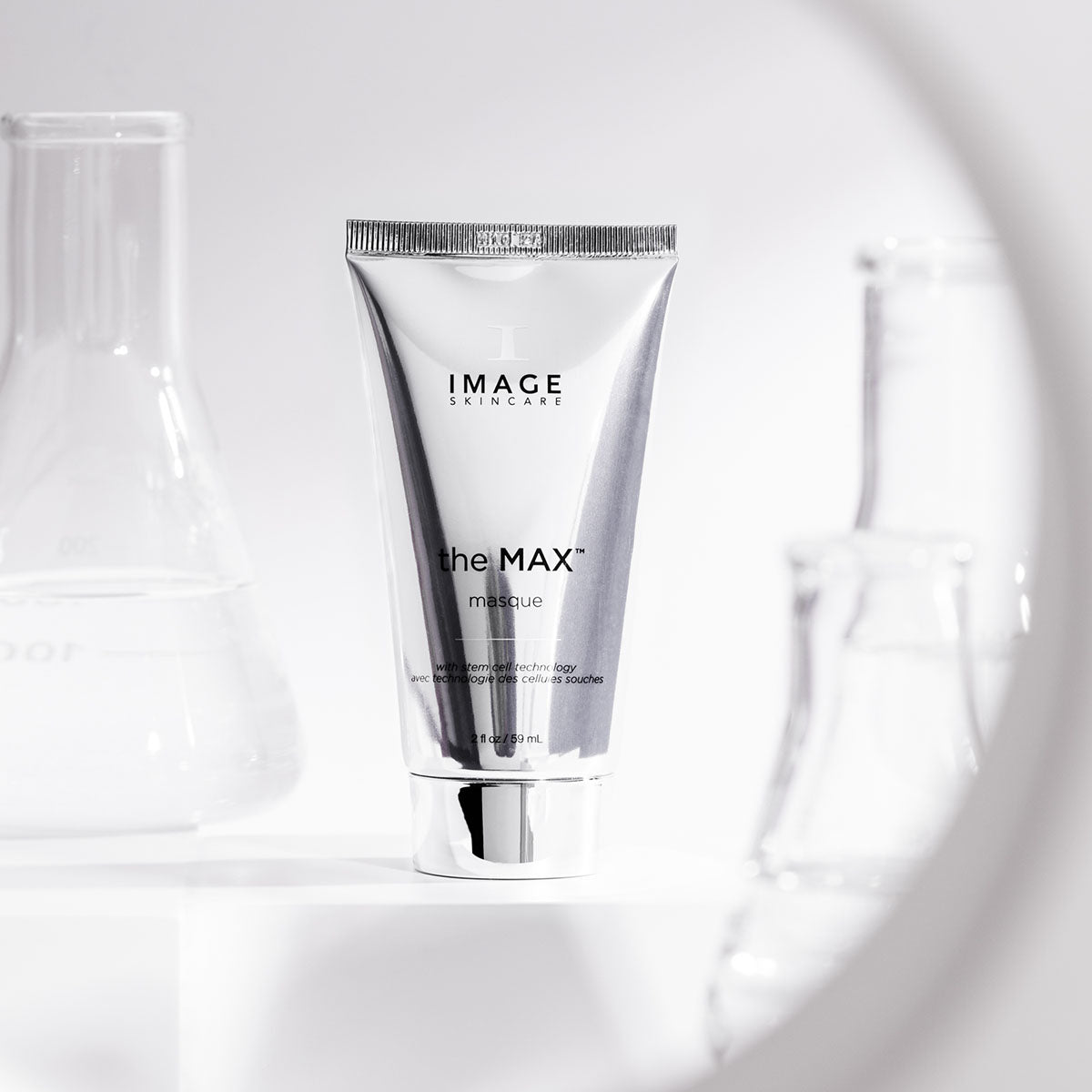 the max masque tube surrounded by beakers on white background