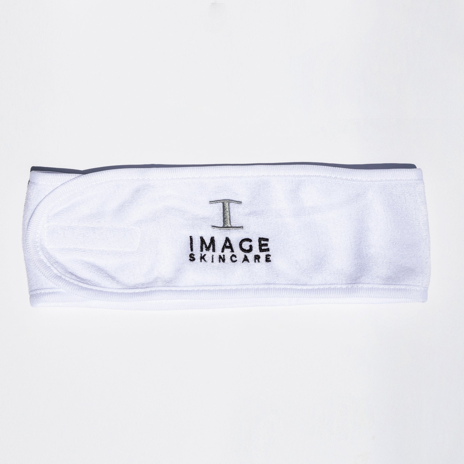 close up of white terry cloth headband with IMAGE skincare logo