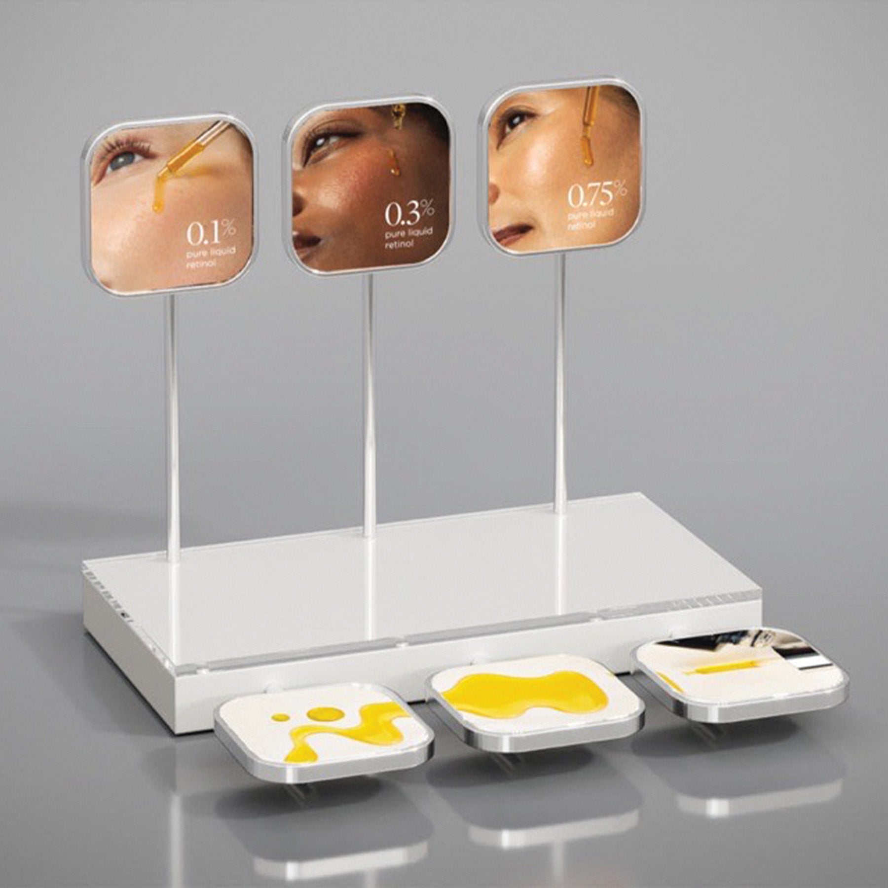 A display unit with three compartments, each containing a different concentration of serum, with labels indicating the percentage of retinol.